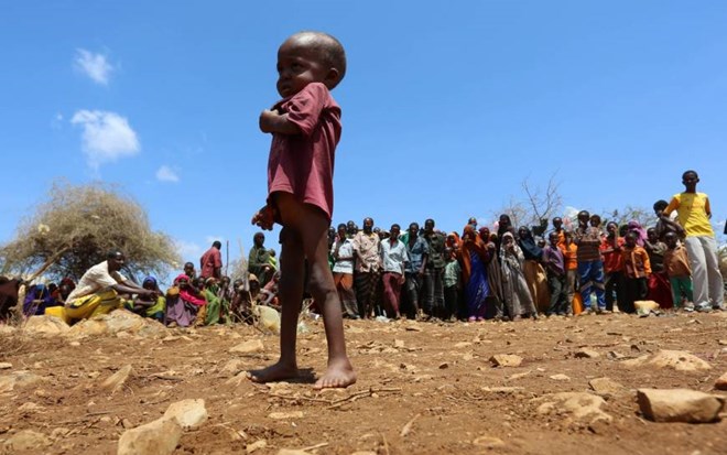An internally displaced Somali child stands among other people who have fled from drought-stricken regions at a makeshift camp in Baidoa, west of Mogadishu, Sunday. | REUTERS